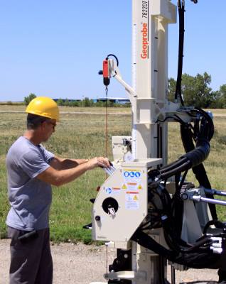 Man operating machinery on a dirt road.